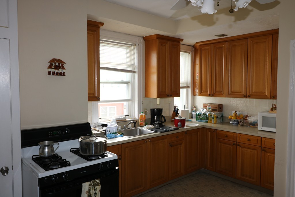 9 Whitby Street Boston, MA 02128 - Photo 4 of 15 a kitchen with a sink stove top oven and cabinets