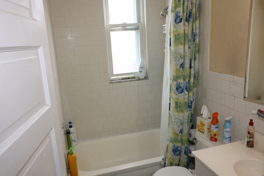 9 Whitby Street Boston, MA 02128 - Photo 5 of 15 a bathroom with a bathtub a sink and a shower curtain