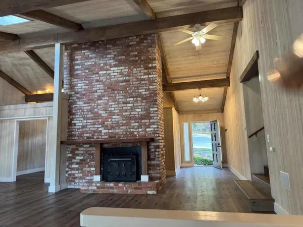 a view of empty room with wooden floor and fireplace