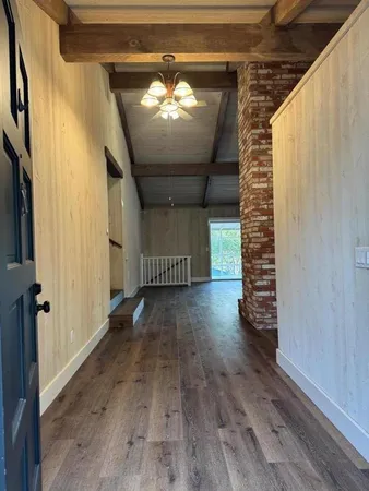 a view of a hallway with wooden floor and staircase