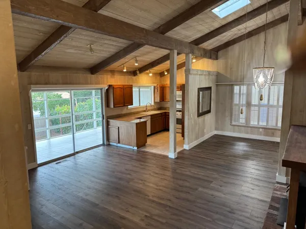 a view of kitchen with stainless steel appliances wooden floor and a large window