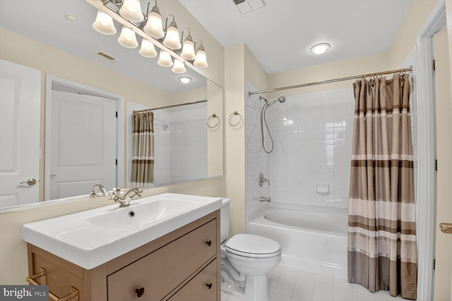 11700 Old Georgetown Road, Unit 714 Rockville, MD 20852 - Photo 14 of 21 a bathroom with a sink toilet a mirror and shower