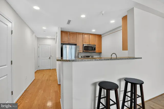 a kitchen with stainless steel appliances granite countertop a sink and a refrigerator