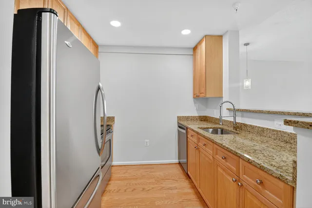 a kitchen with stainless steel appliances granite countertop a refrigerator and a sink