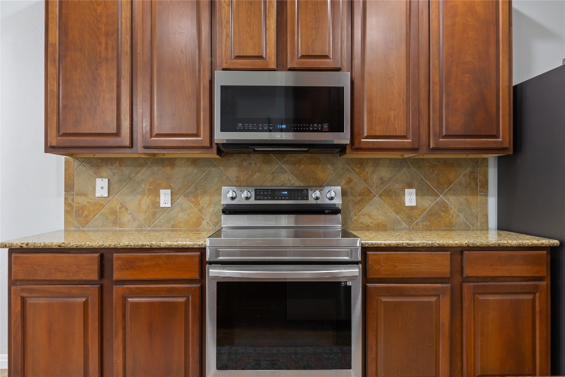 11237 Lost Maples Trail Austin, TX 78748 - Photo 13 of 35 a kitchen with granite countertop wood cabinets and stainless steel appliances
