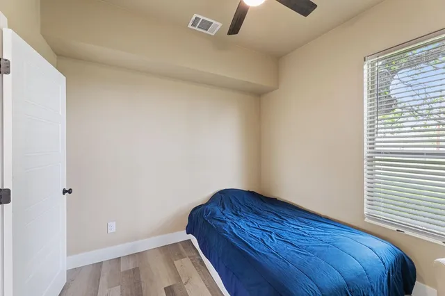 a bedroom with a bed and a ceiling fan