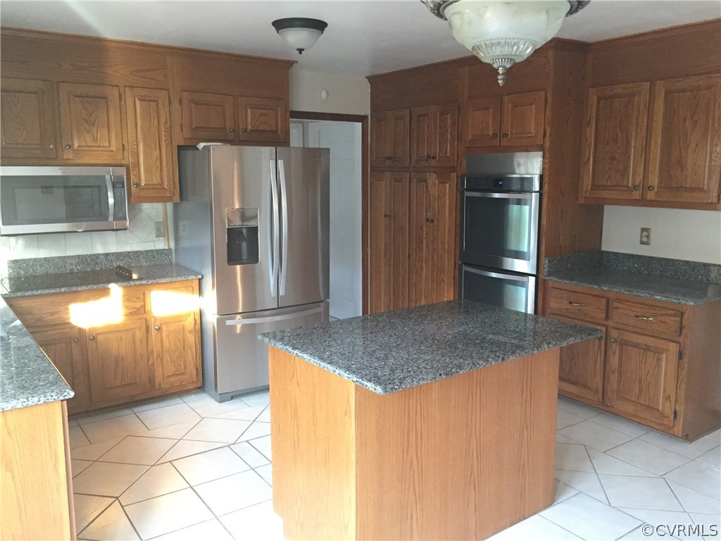 3807 Doe Run Road Hopewell, VA 23860 - Photo 2 of 29 a kitchen with kitchen island granite countertop a refrigerator a stove and a sink with granite countertops