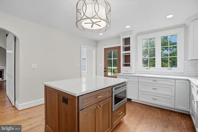 a kitchen with a stove cabinets and wooden floor