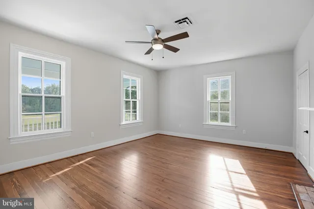 wooden floor in an empty room with a window