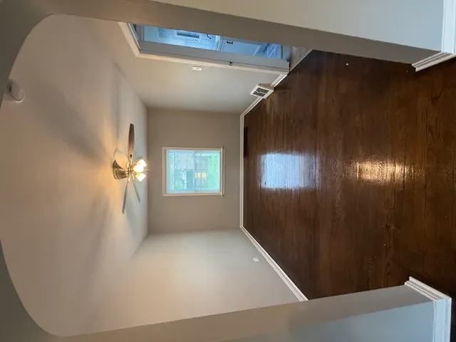 a view of empty room with wooden floor