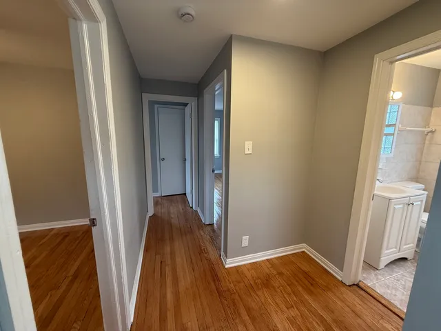 a view of a hallway with wooden floor and staircase