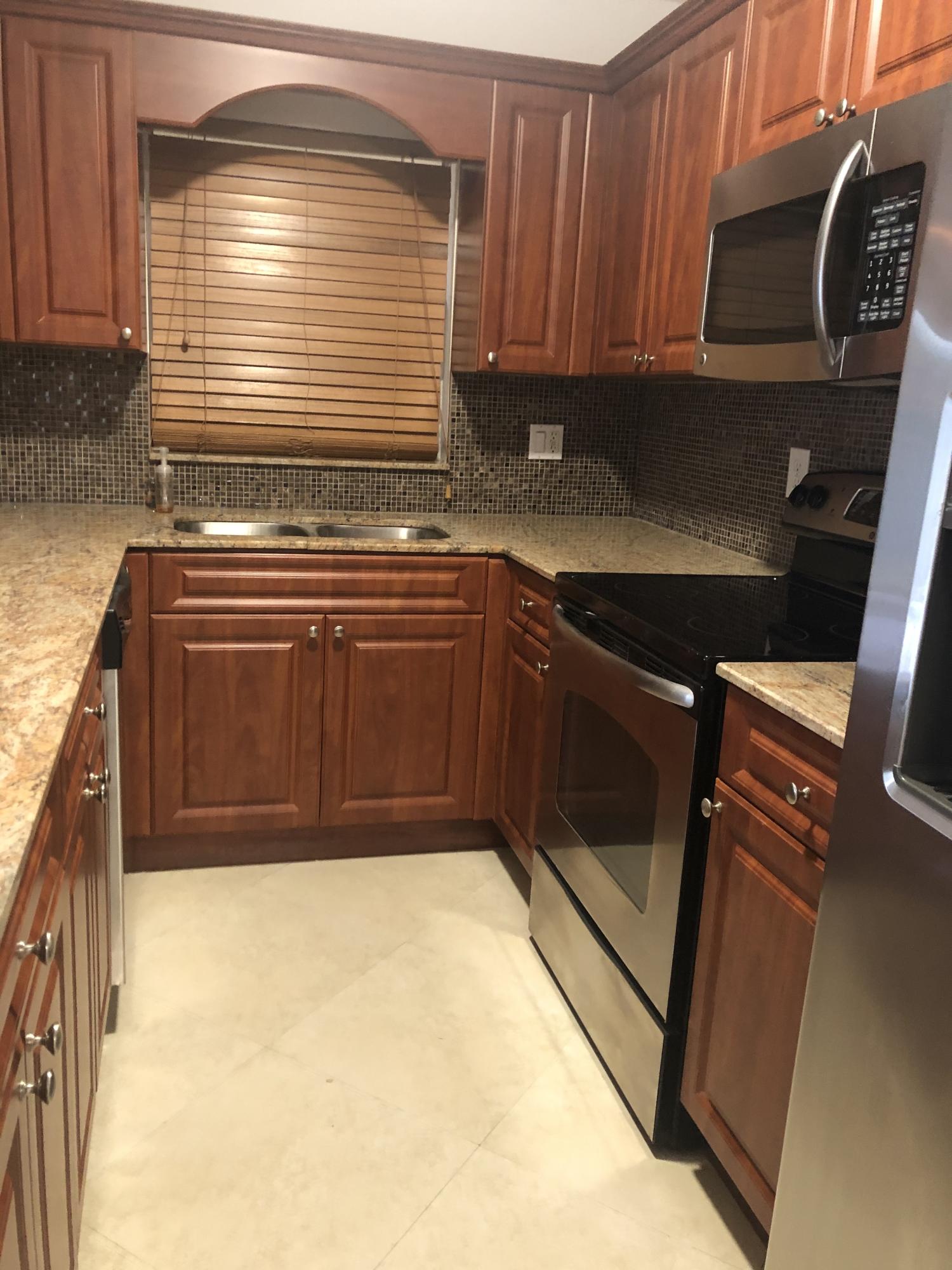 1291 Northwest 13th Street, Unit 346D Boca Raton, FL 33486 - Photo 3 of 15 a kitchen with granite countertop a stove and a sink
