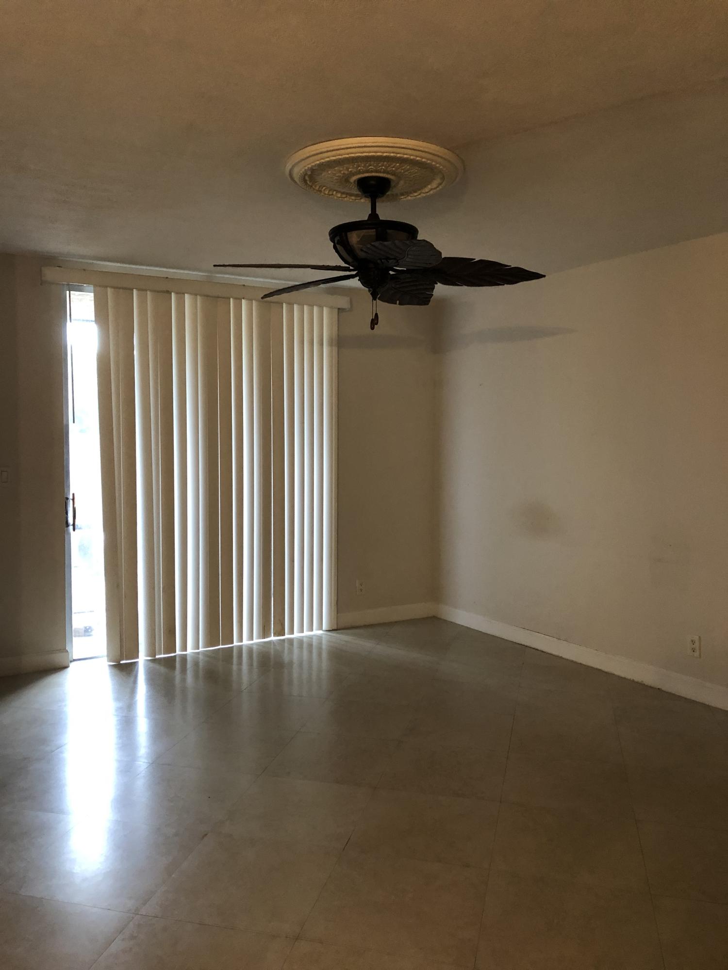 1291 Northwest 13th Street, Unit 346D Boca Raton, FL 33486 - Photo 7 of 15 a view of a livingroom with a ceiling fan and window