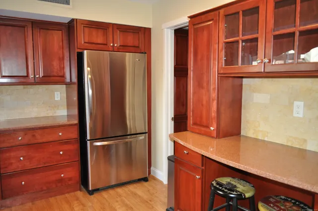 a kitchen with stainless steel appliances granite countertop a refrigerator and cabinets