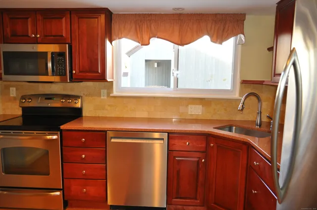 a kitchen with stainless steel appliances granite countertop a sink stove and microwave
