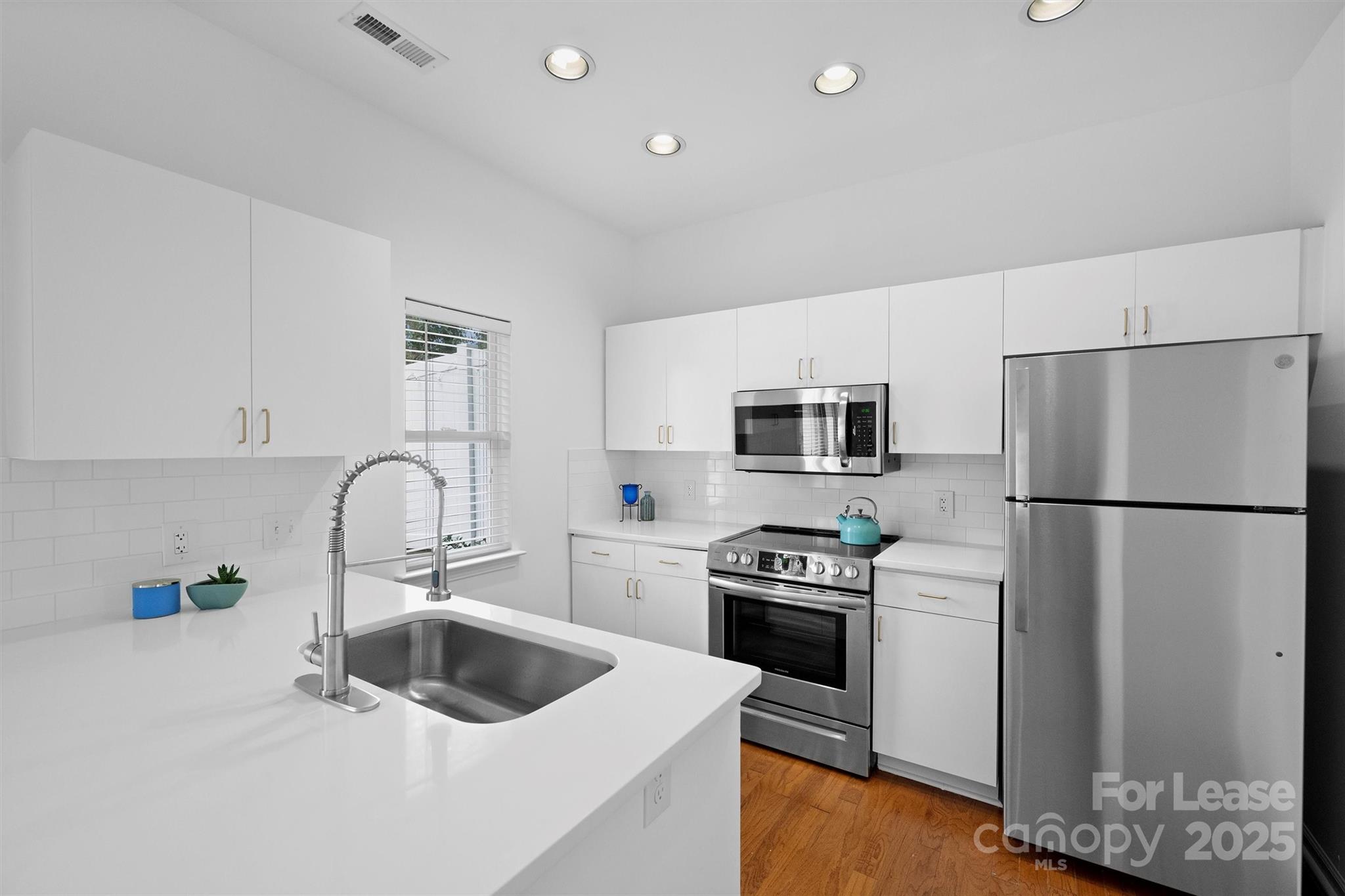 2252 Vision Drive Charlotte, NC 28203 - Photo 13 of 30 a kitchen with a refrigerator sink and white cabinets