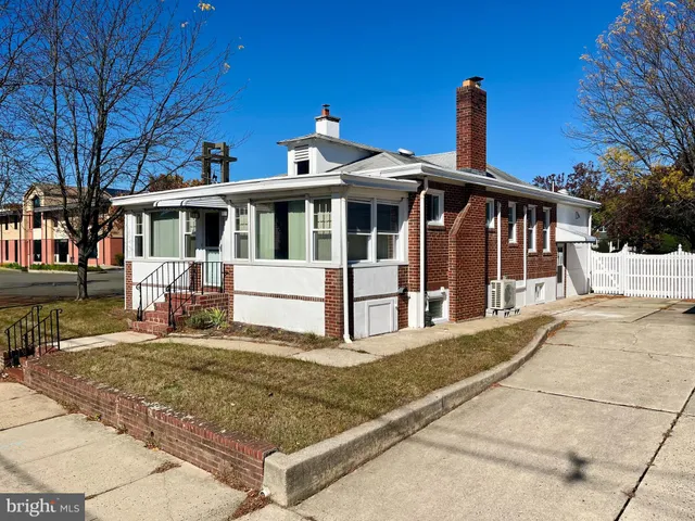 a view of a house with large windows and a small yard