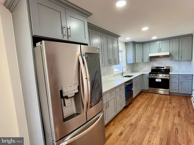 a kitchen with stainless steel appliances granite countertop a refrigerator a sink and a stove