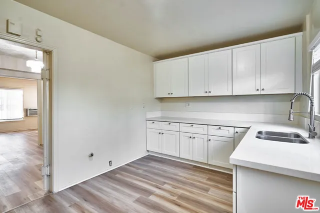a kitchen with granite countertop white cabinets and white appliances