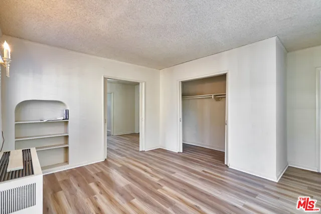 a view of a room with wooden floor cabinet and a bathroom