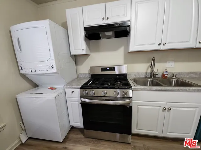 a kitchen with white cabinets and white appliances