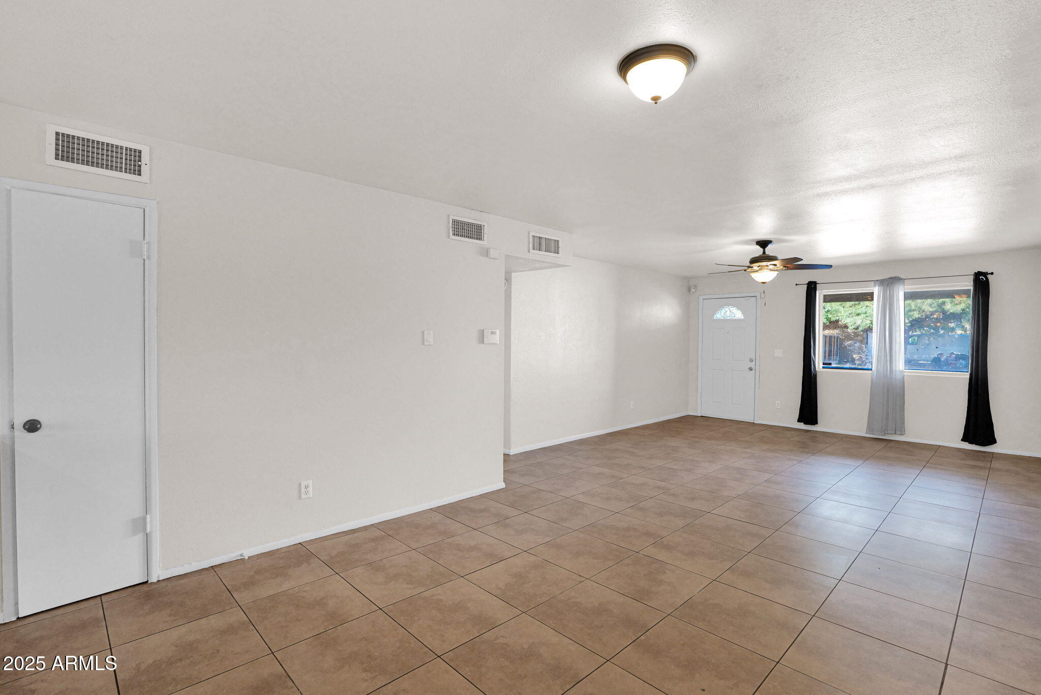 7221 Virginia Avenue Phoenix, AZ 85035 - Photo 16 of 33 an empty room with fan and windows