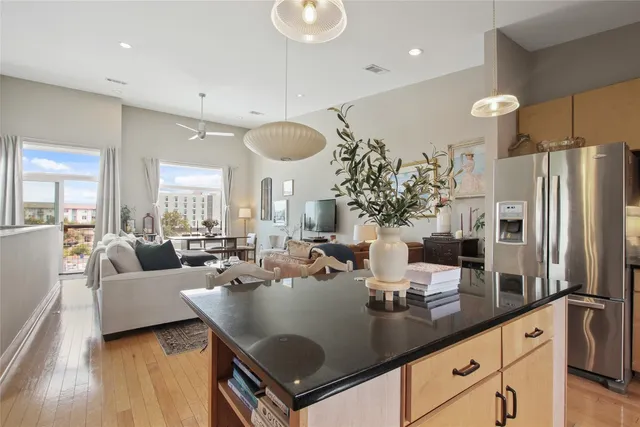 a living room with furniture kitchen view and a flat screen tv