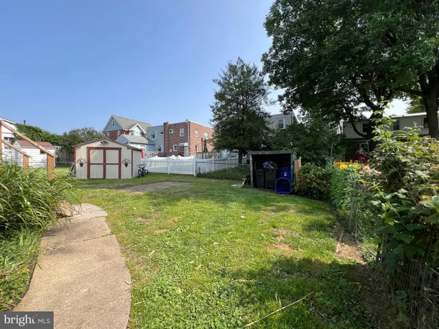 a view of a house with a yard and a large tree