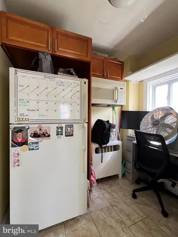 a utility room with a refrigerator and a stove top oven