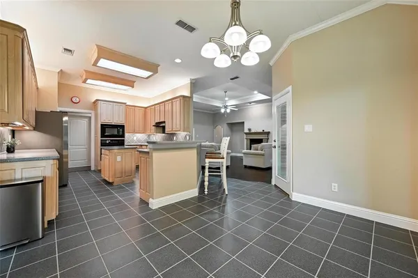 a kitchen with stainless steel appliances a sink a stove a refrigerator cabinets and living room view