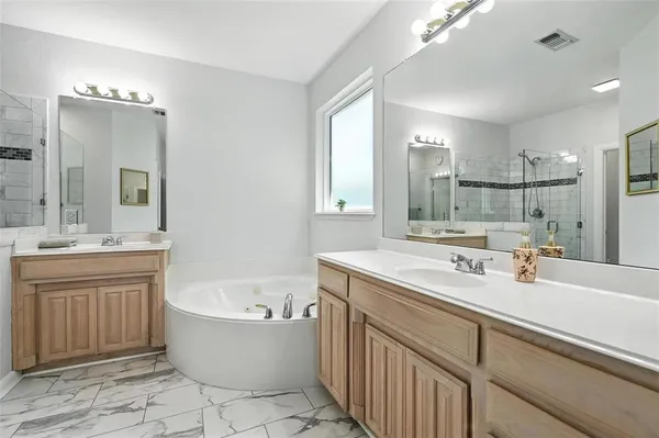 a bathroom with a tub sink and mirror