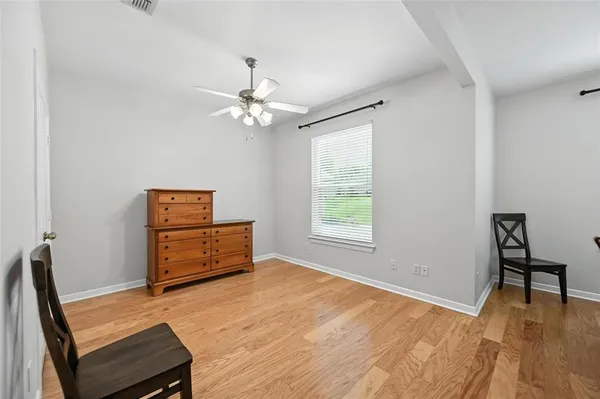 an empty room with windows and ceiling fan