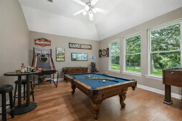 a living room with furniture a pool table and a large window