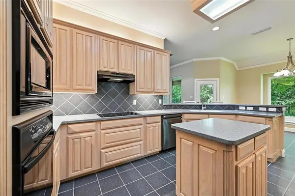 a kitchen with granite countertop a sink stove and cabinets