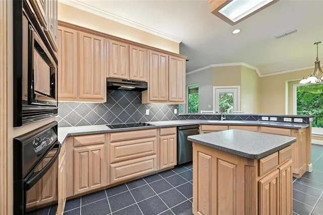 a kitchen with granite countertop a sink stove and cabinets