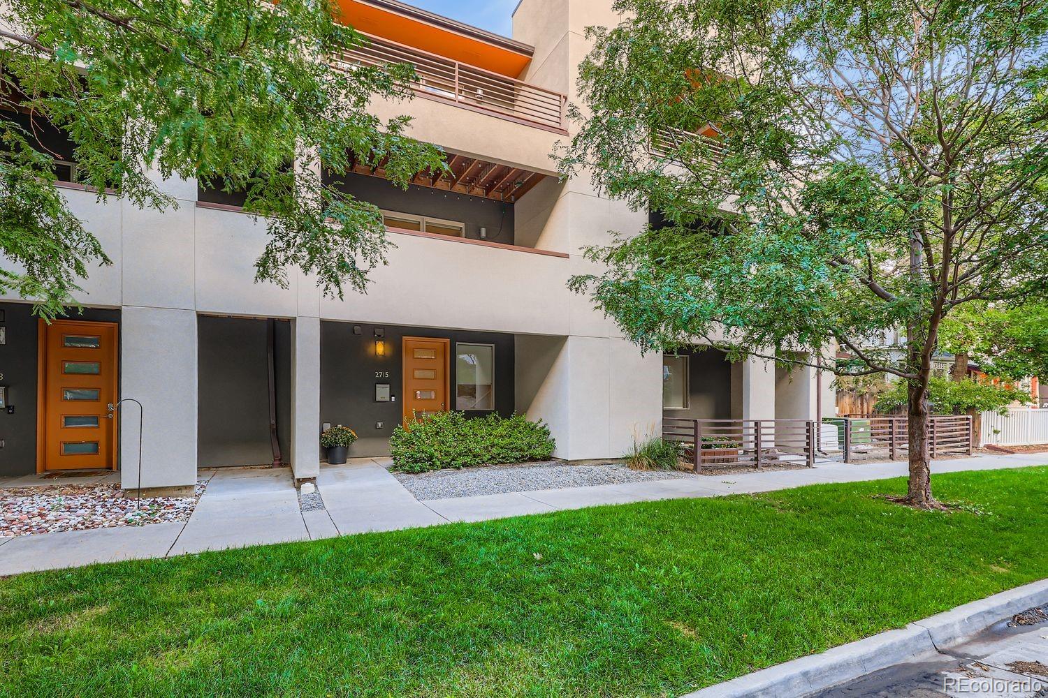 a front view of a house with a yard and green space