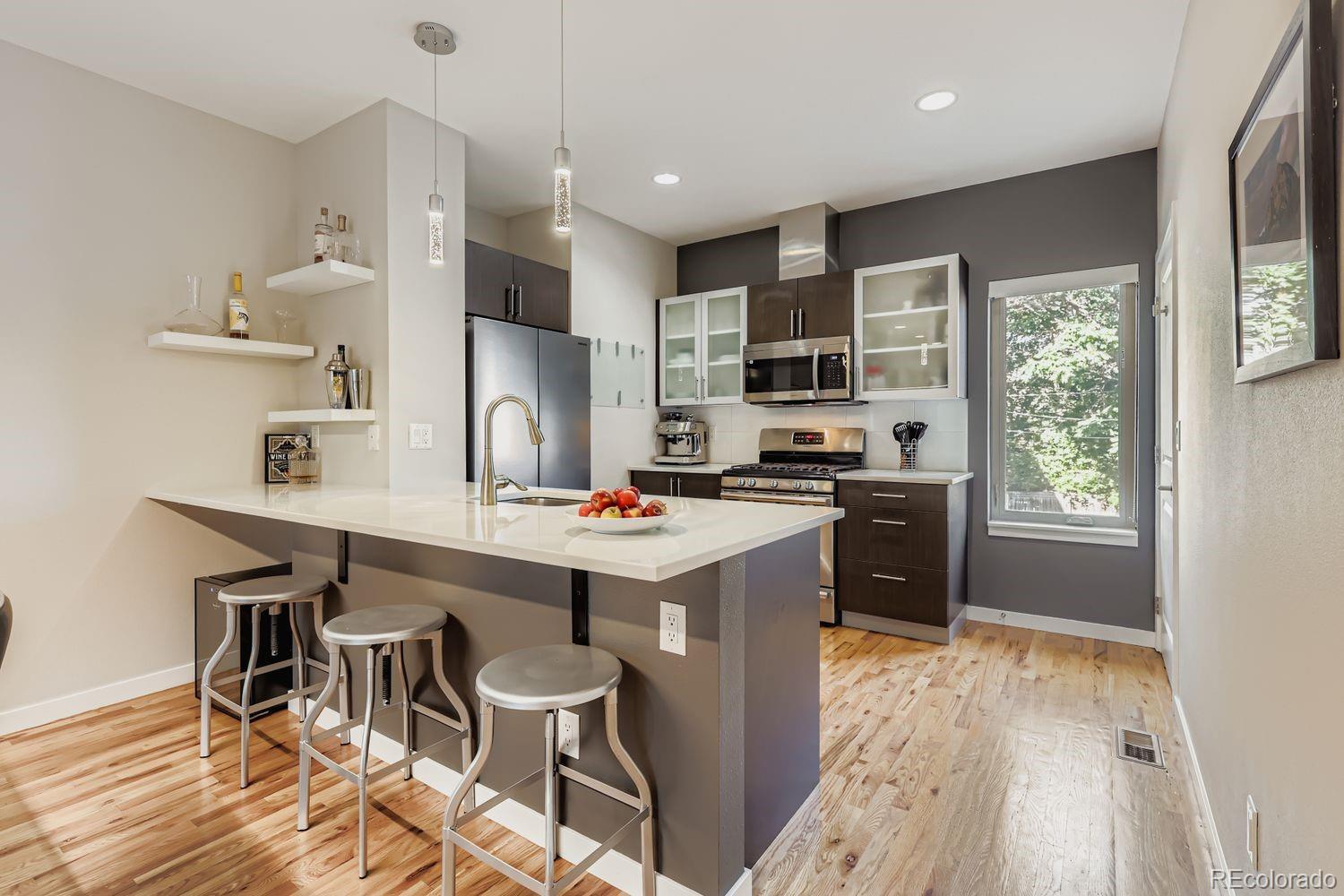 2715 Decatur Street Denver, CO 80211 - Photo 11 of 39 a kitchen that has a table chairs in it wooden floor and a window