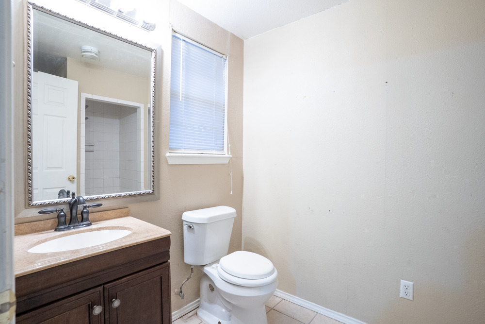 207 Harris Street Elgin, TX 78621 - Photo 15 of 19 a bathroom with a toilet a sink and mirror