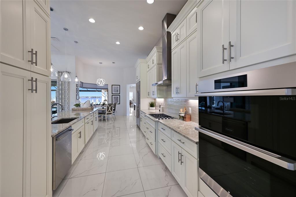 700 Regatta Way Bradenton, FL 34208 - Photo 23 of 78 a large white kitchen with stainless steel appliances and a cabinets