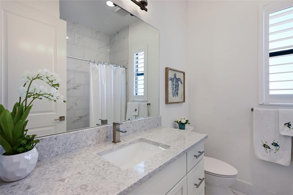 700 Regatta Way Bradenton, FL 34208 - Photo 32 of 78 a bathroom with a granite countertop sink a toilet and shower