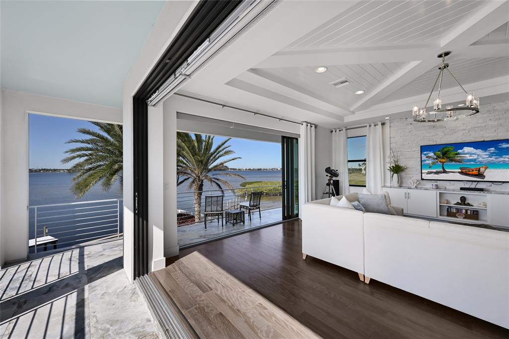 700 Regatta Way Bradenton, FL 34208 - Photo 48 of 78 a living room with furniture a chandelier and a flat screen tv