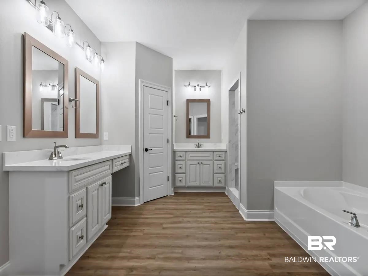 10174 Grady Lane Mobile, AL 36695 - Photo 9 of 14 Full bath featuring two vanities, a bath, and dark wood finished floors
