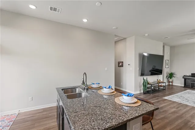 a kitchen with granite countertop kitchen island stainless steel appliances a sink and cabinets