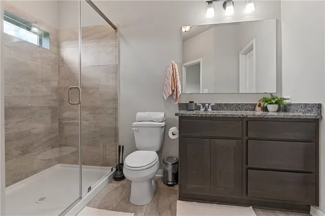 a bathroom with a granite countertop sink toilet and shower