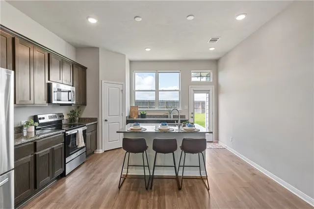 a kitchen with a table chairs stove and cabinets