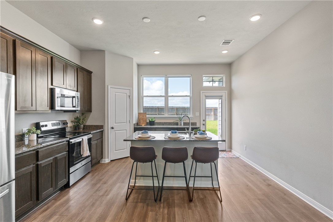 4746 Holm Oak Road College Station, TX 77845 - Photo 10 of 25 a kitchen with a table chairs stove and cabinets