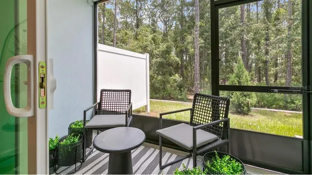 a view of a balcony with chairs and a potted plant
