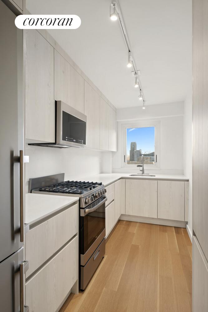 520 East 76th Street, Unit 4H Manhattan, NY 10021 - Photo 2 of 10 a kitchen with a stove a sink and a microwave