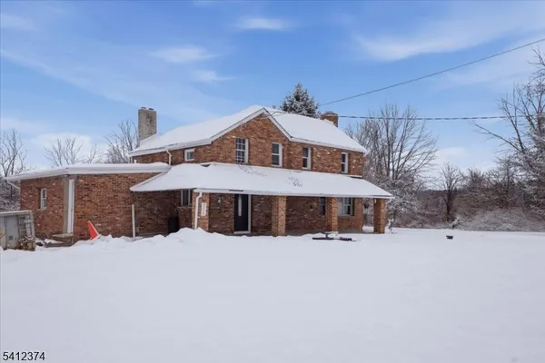 a view of a house with a yard covered in snow