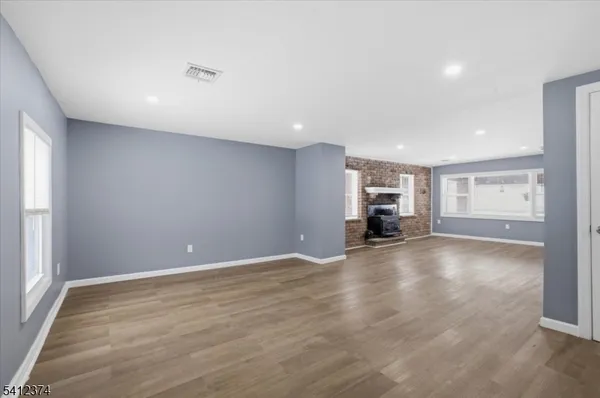 a view of empty room with wooden floor and window